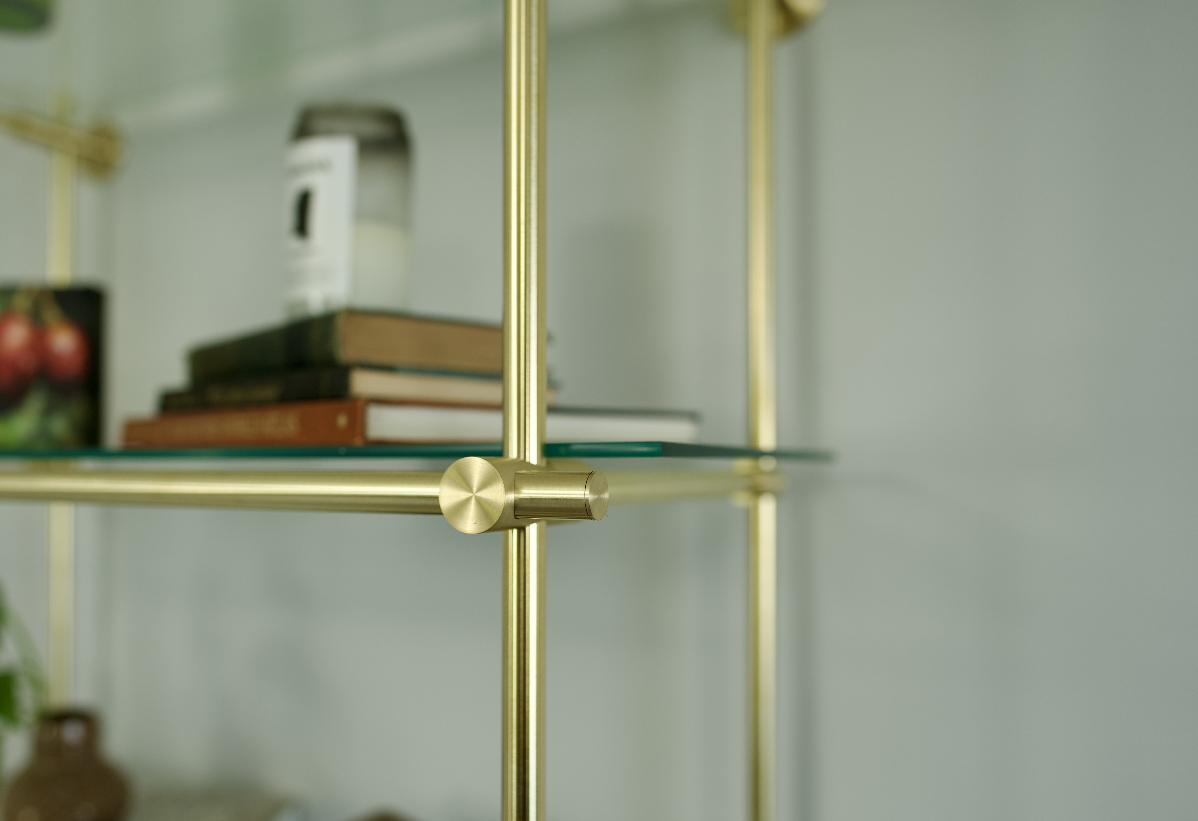 Custom brass shelving styled with books and decorative accents by Cortavelle